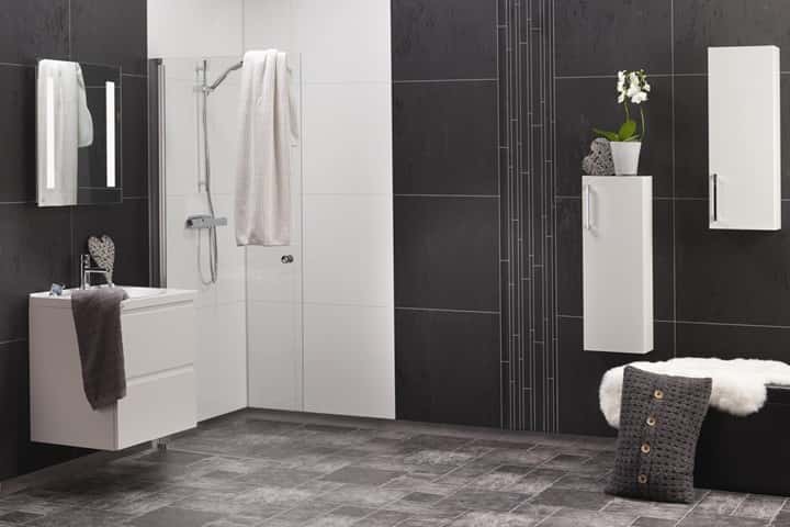 Badkamer met antracietgrijze en witte wandpanelen, een inloopdouche, wit wastafelmeubel en hoge kast.