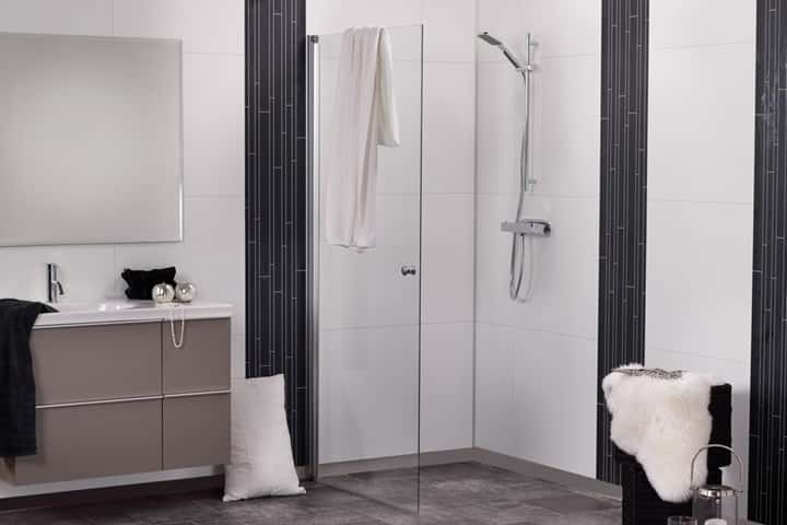 Badkamer met witte panelen en zwarte accentstroken, een inloopdouche en een taupe wastafelmeubel.