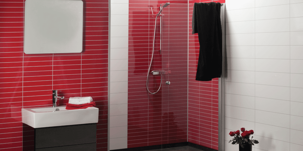 Badkamer met rode tegellook-panelen in de douchehoek, witte wandpanelen, wastafel en spiegel.