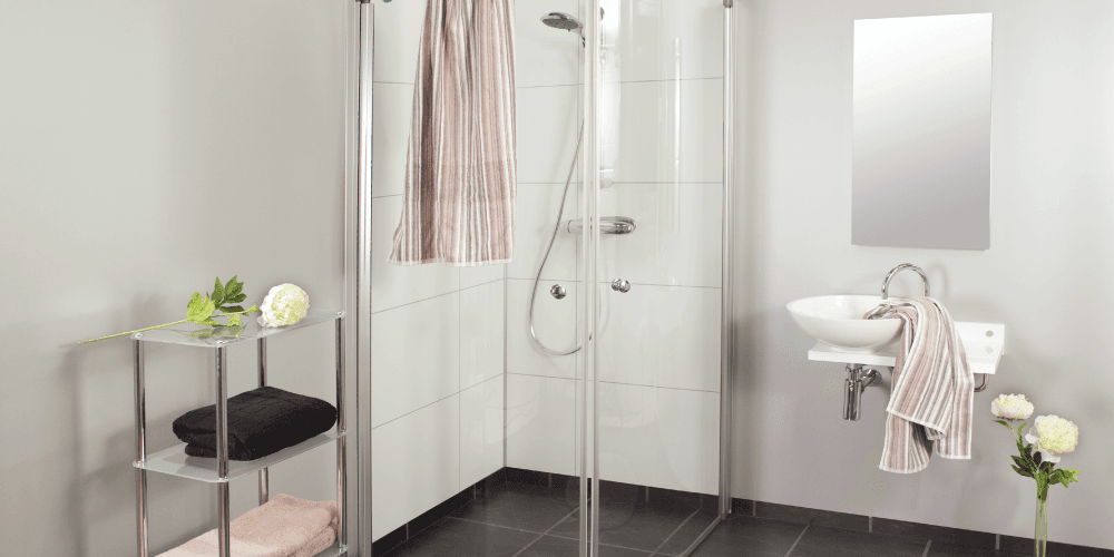 Badkamer met witte wandpanelen, een douchecabine, een witte wastafel en witte bloemen.